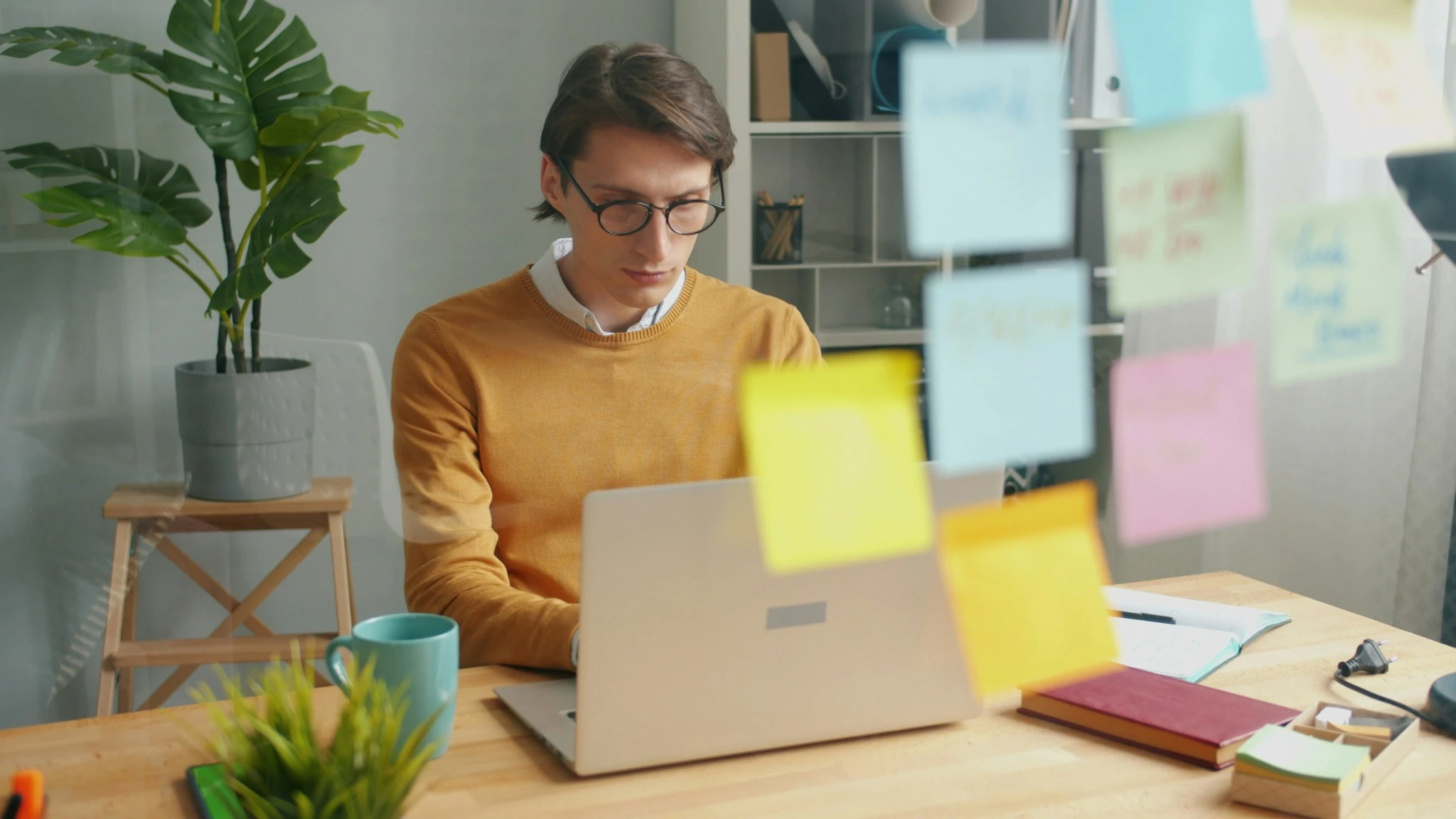 Mann arbeitet konzentriert am Laptop in einem hellen Büro